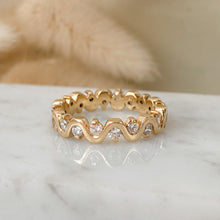 Load image into Gallery viewer, An undulating wave ring of 14k gold with diamonds on marble surface