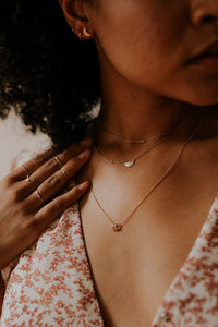 woman-wearing-stacks-of-minimal-gold-necklaces