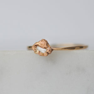 Delicate raw baguette diamond ring in melted gold.